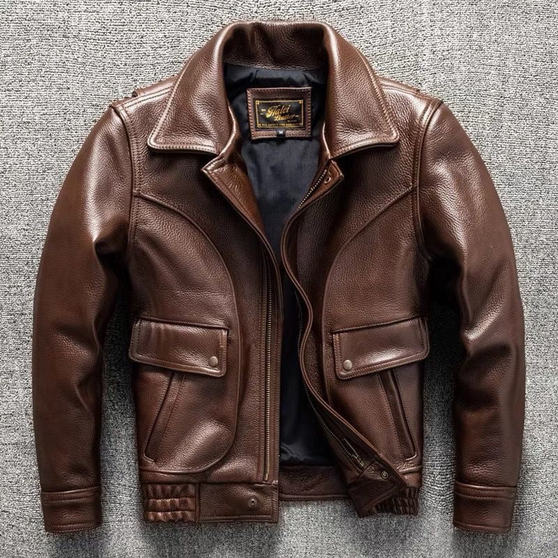 Brown leather jacket front view with stand collar, zip front, two flap pockets, and stitched hem belt