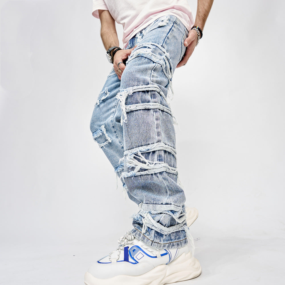 Distressed light-blue denim wide-leg trousers with layered, frayed panels and strap details