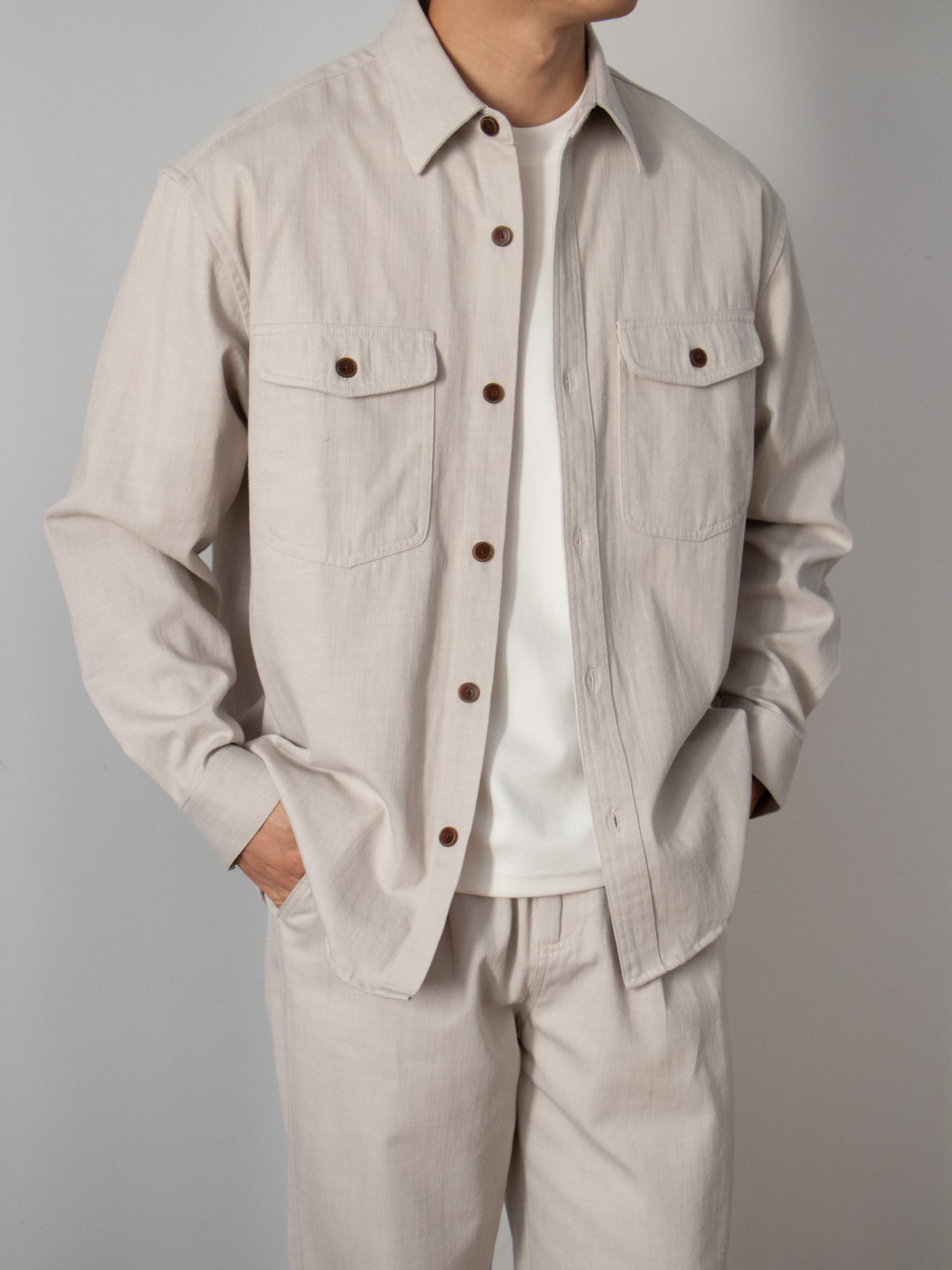 Light cream long-sleeve button-up shirt with two chest flap pockets, loose fit.