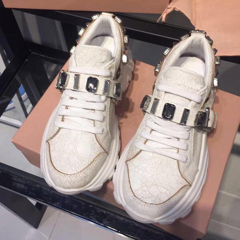 Women's white platform sneakers, textured finish with silver buckle strap and laces