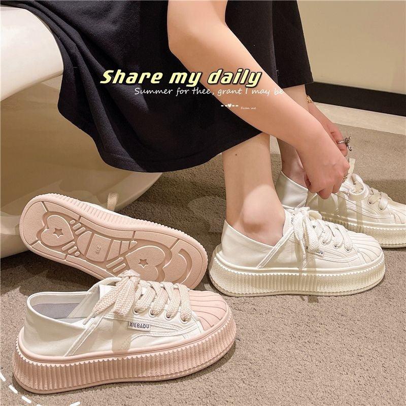 White lace-up platform sneakers with textured rubber sole and stitched toe cap