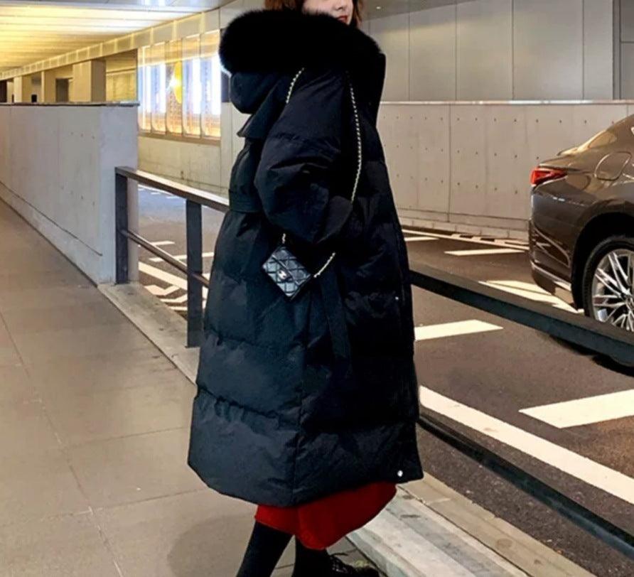 Mid-length down jacket in black with oversized faux-fur hood, button front, belted waist