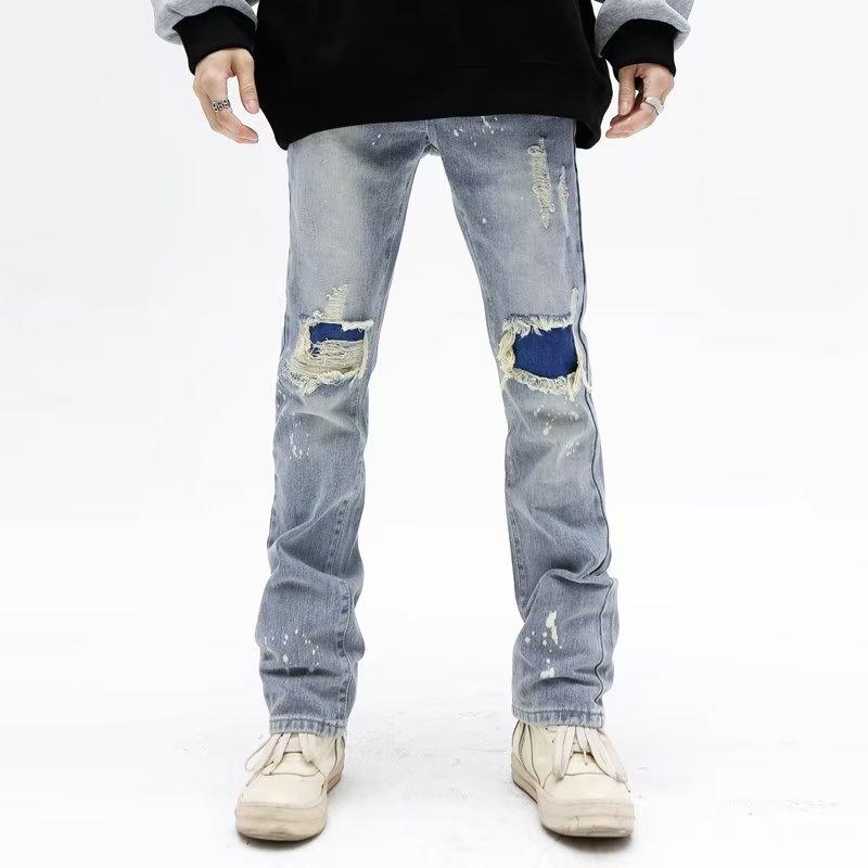 Light blue ripped jeans with blue patch distressing at the knees and worn hems