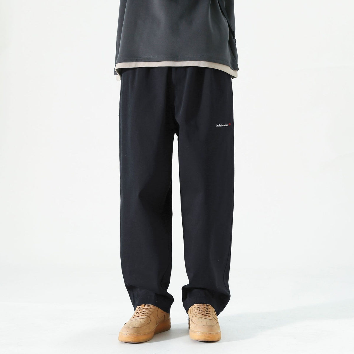 Men's loose cargo pants in dark color, straight leg, cuffed hems, small logo on leg