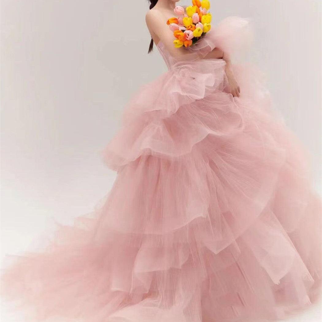 Girls pink sleeveless tiered tulle wedding dress with ruffled skirt and layered bodice.