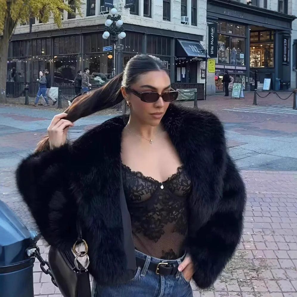 Dark faux fur fluffy jacket with wide collar and long sleeves on a model outdoors.