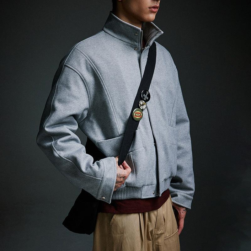 Gray padded wool coat with stand-up collar, full zip front, and flap pockets