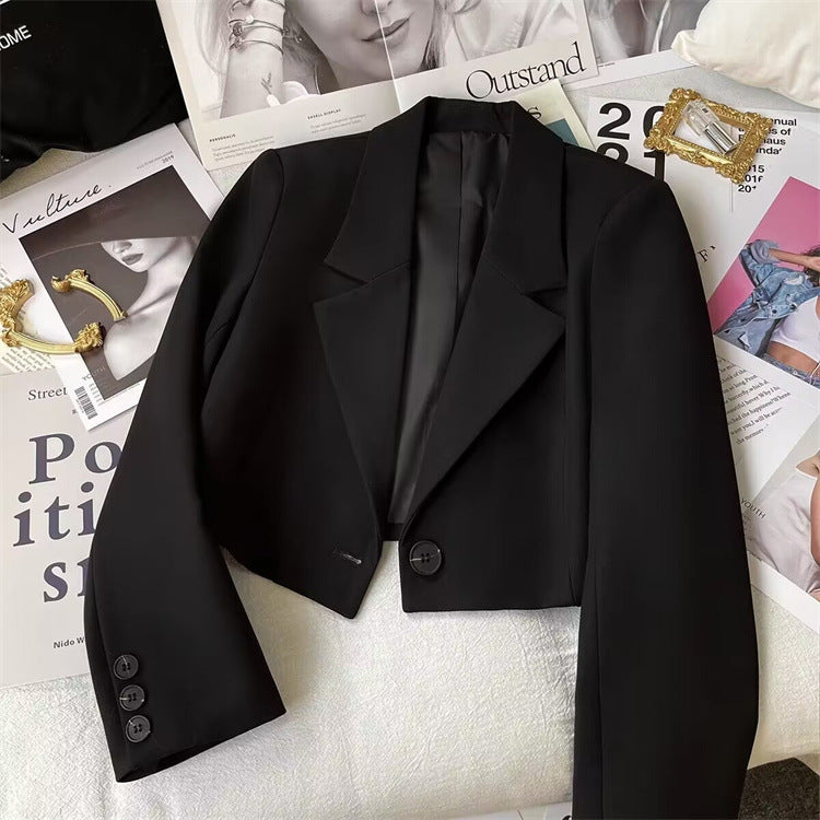 Black petite blazer with notch lapel, flap pockets, and button front