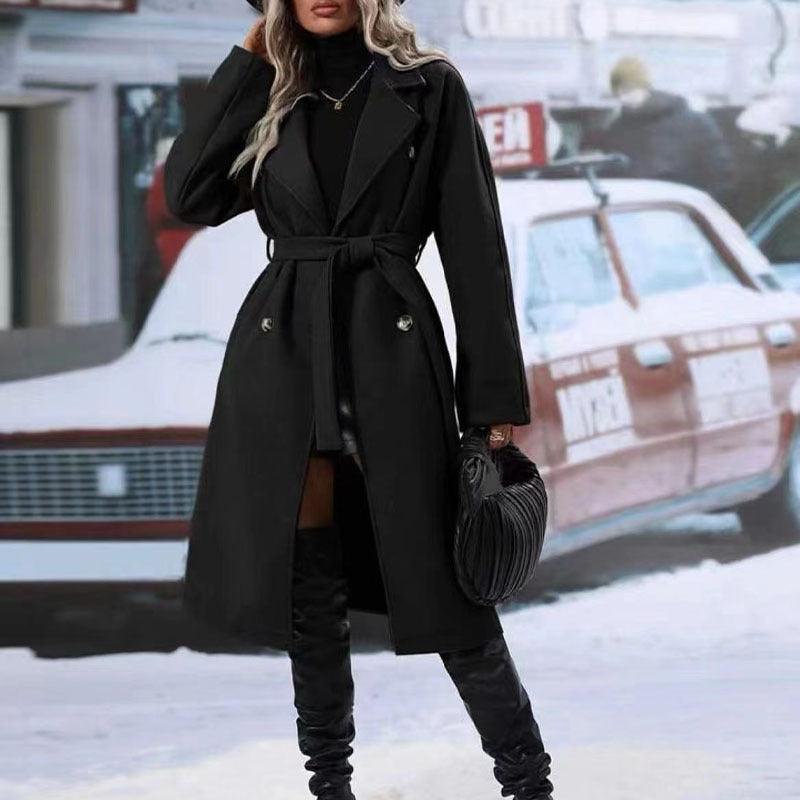 Black double-breasted trench coat with notched lapels and waist belt tie