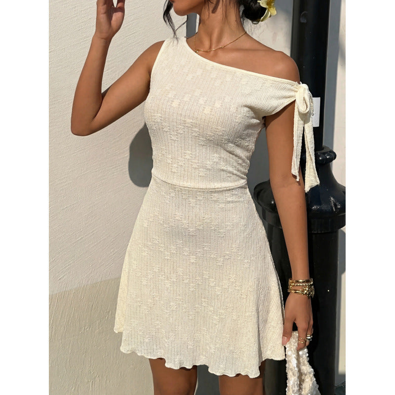 Beige textured off-shoulder mini dress, side view with bow-tied strap and flared hem