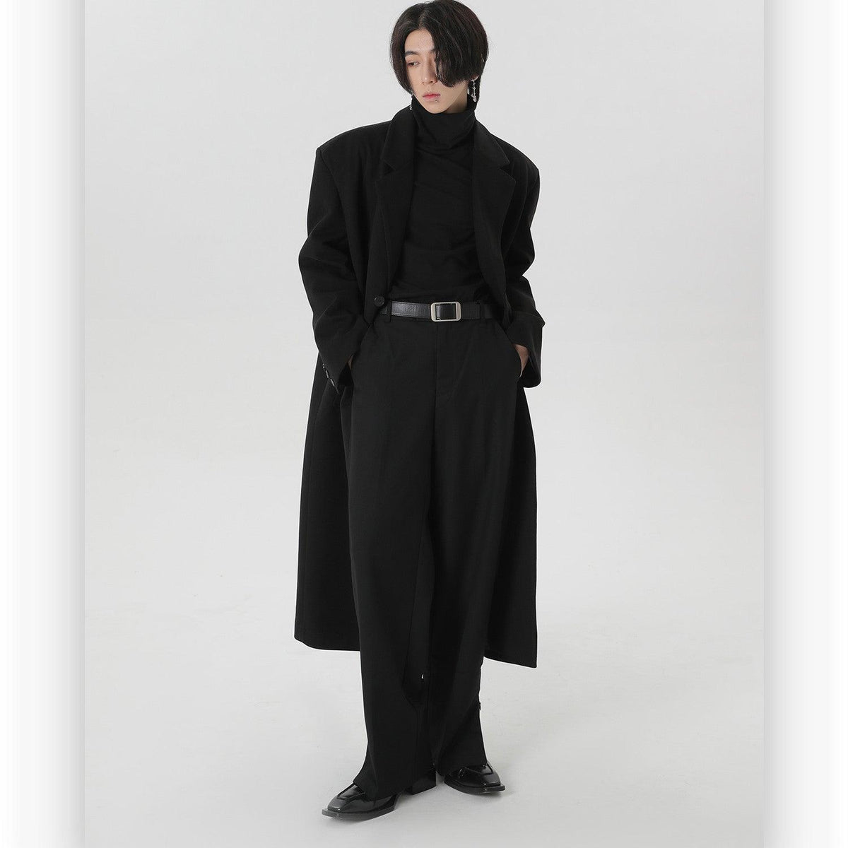 Black long wool overcoat with notched lapels, button front, and waist belt