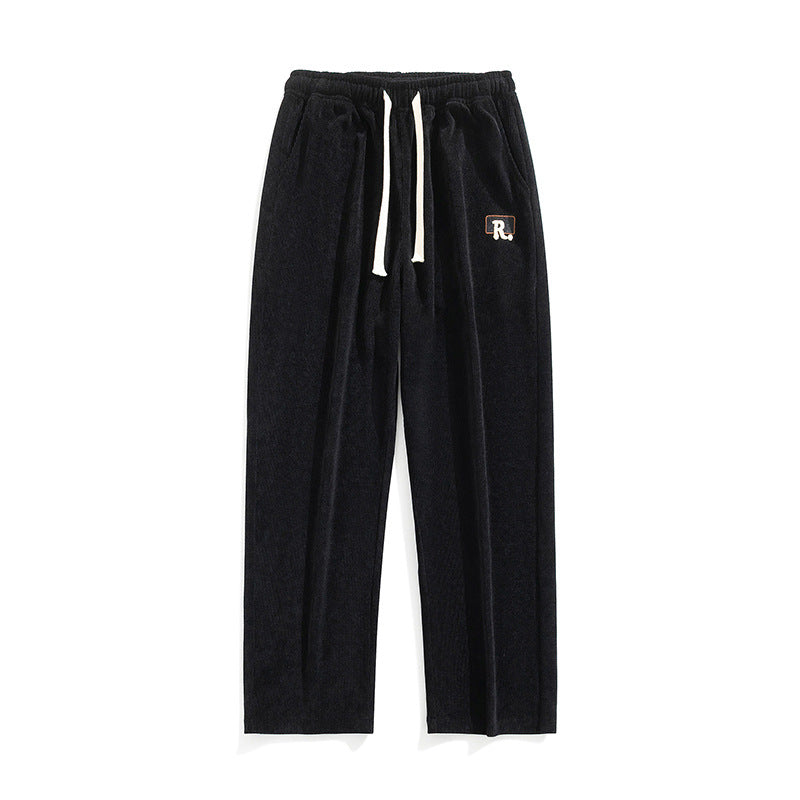 Men's draped casual pants, black with elastic waistband and drawstring ties, logo patch