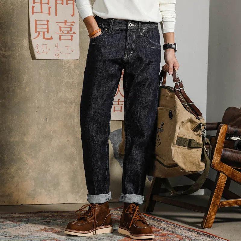 Men's dark indigo workwear jeans with belt loops, front pockets, and cuffed hem