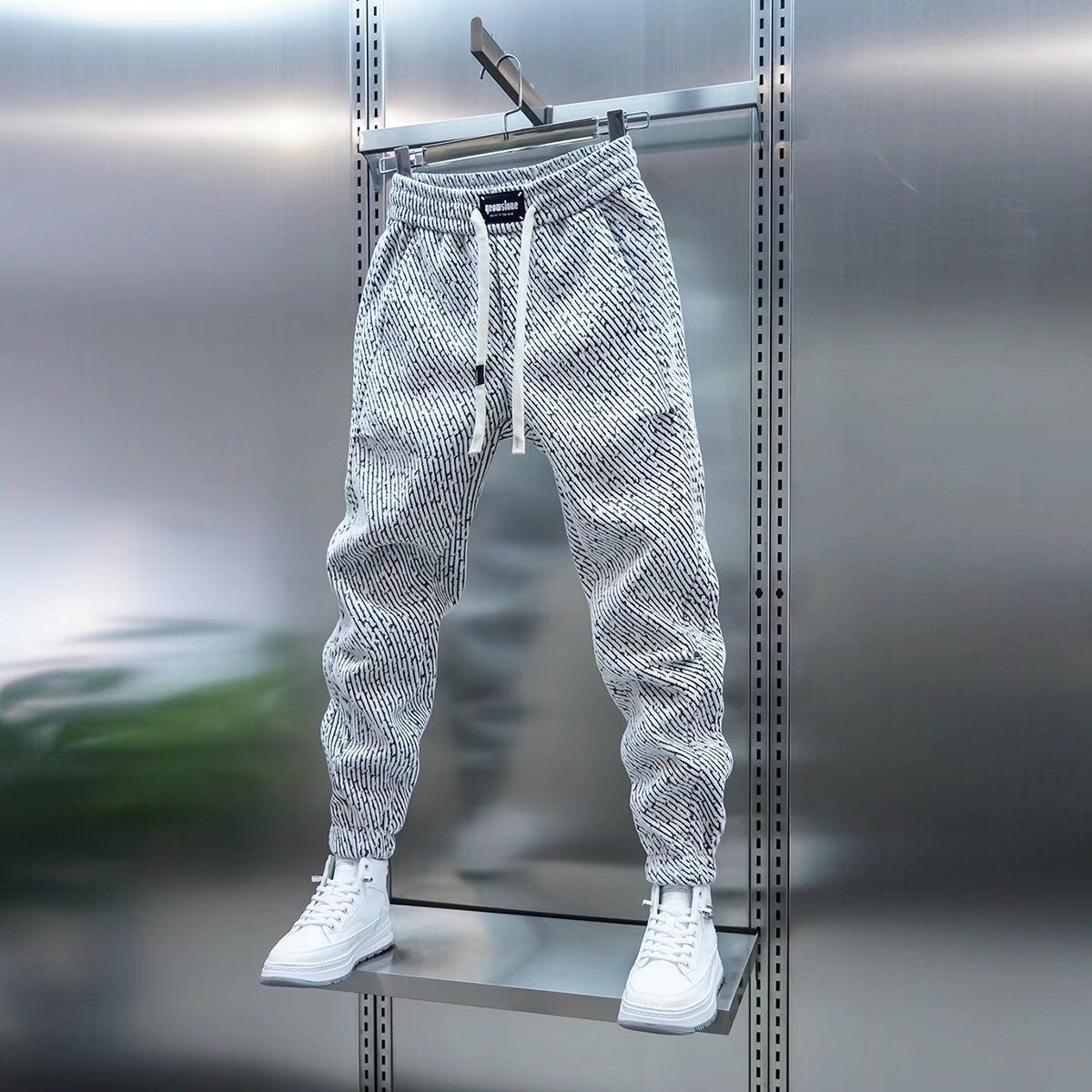 Men's loose sweatpants, heather gray speckled texture, front drawstring, tapered cuffs.