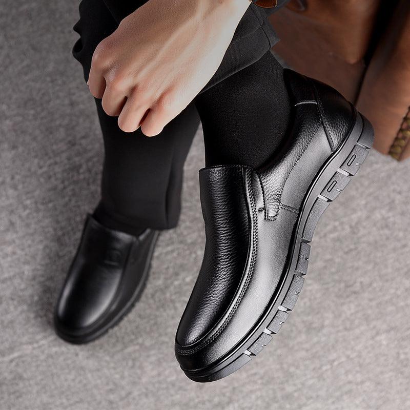 Black leather slip-on business shoes being worn, showing low profile tread