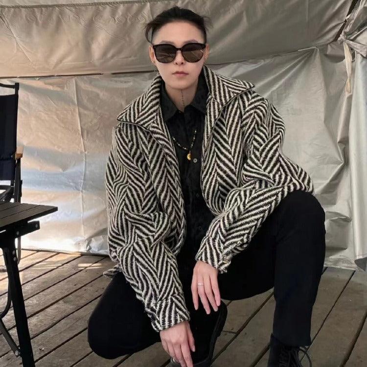 Chevron herringbone coat with wide lapels, long sleeves, and black button front