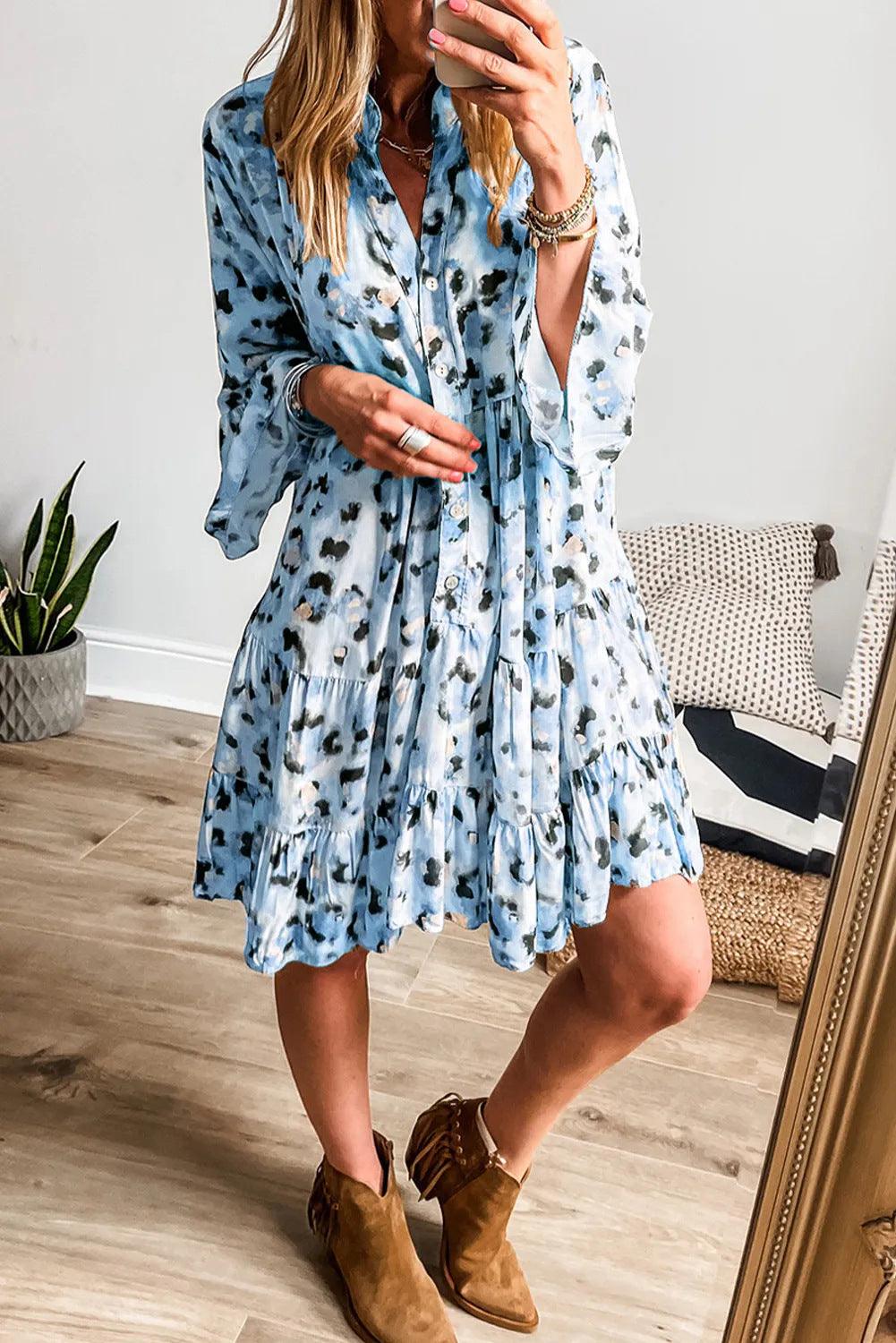 Women's button-front loose dress in light blue with black floral spots, tiered skirt