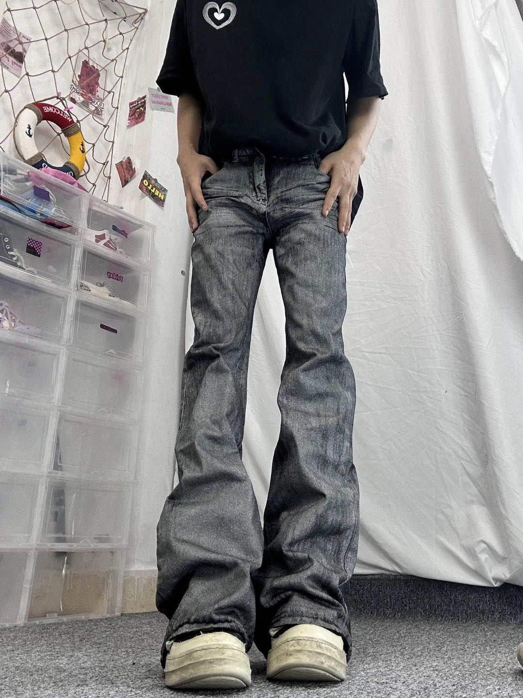 Gray distressed denim jeans with flared straight legs and cuffed hem