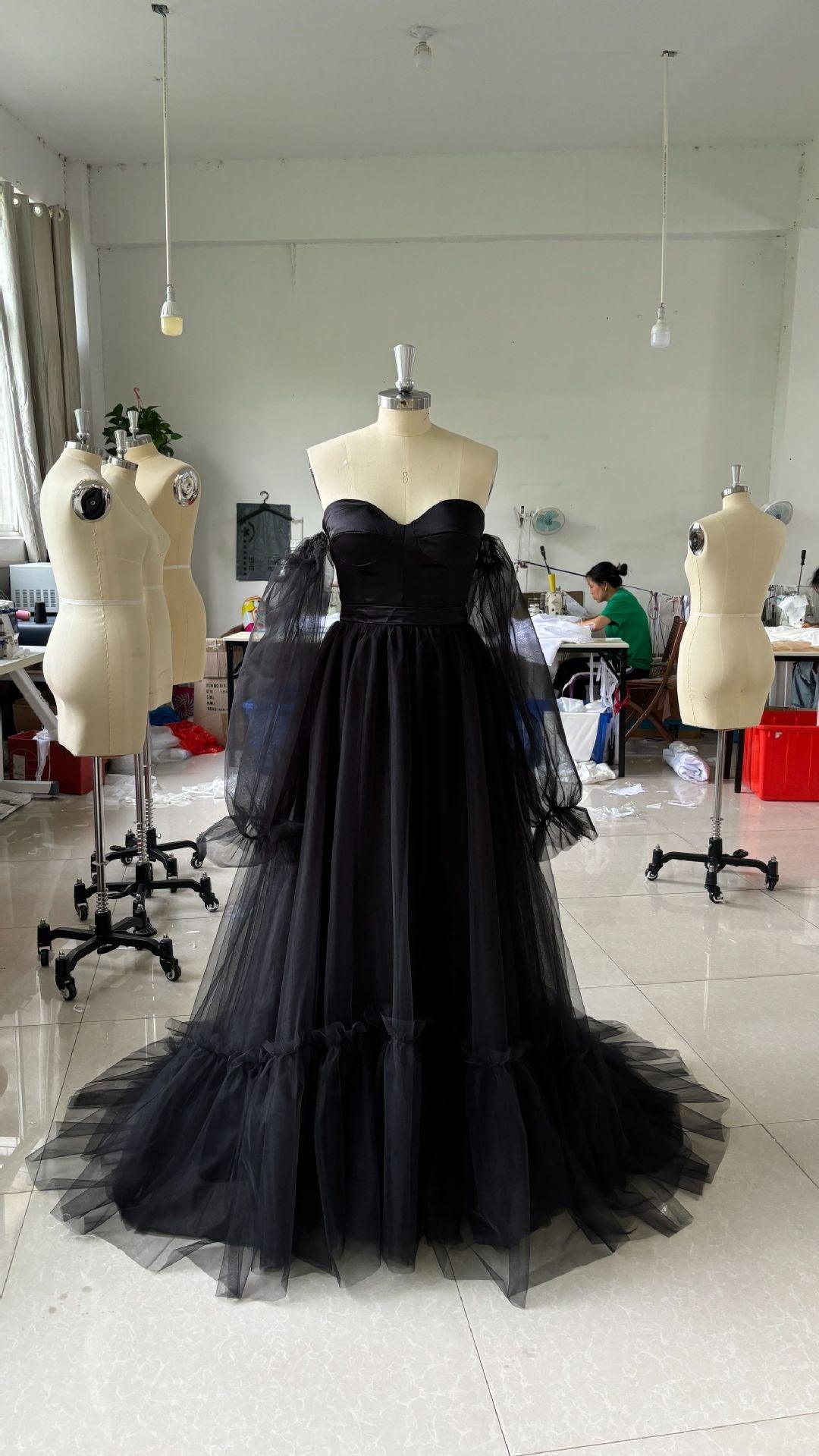 Black lace wedding dress on mannequin, off-shoulder bodice with full tulle skirt