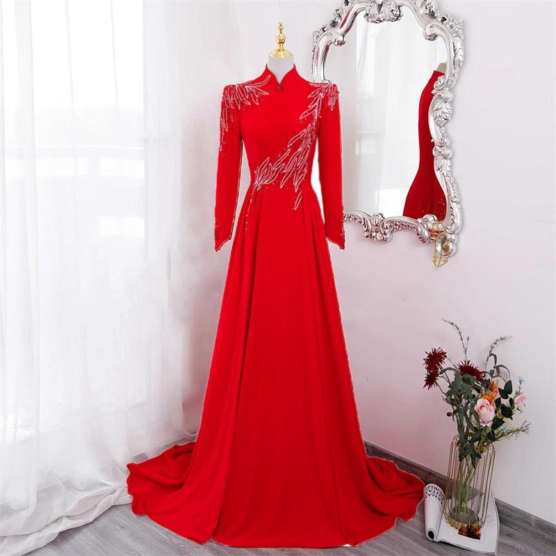 Red long-sleeve formal evening dress with embellished sleeve detailing and flowing skirt