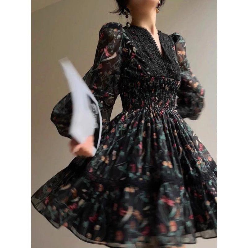Black V-neck dress with sheer floral sleeves and gathered pleated flared skirt