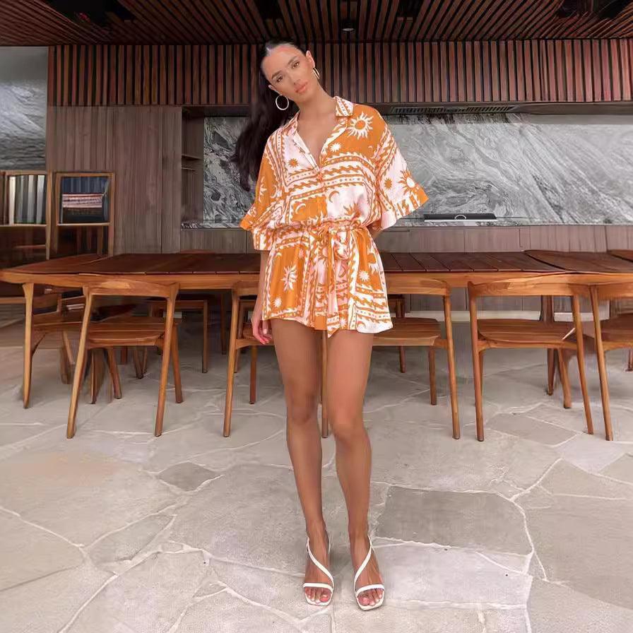 Geometric printed lace-up jumpsuit, orange and white, V-neck with tie waist, short sleeves