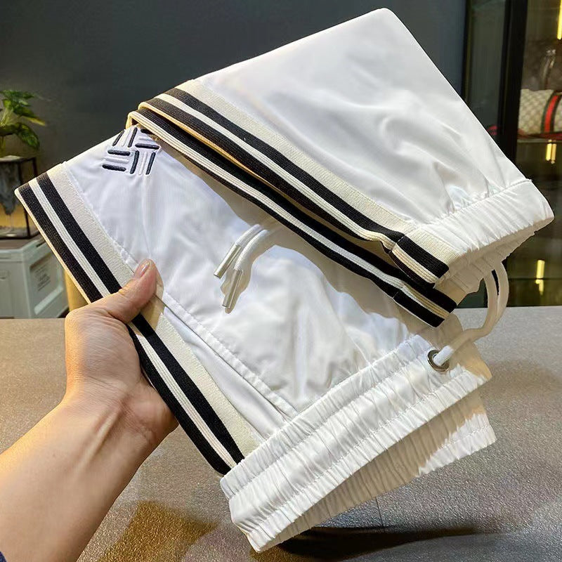 Ice-silk pants in white with black-and-gold side stripes, drawstring waist, elastic cuffs