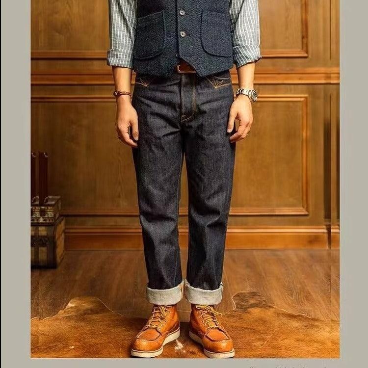 Men's straight dark blue denim jeans with rolled cuffs and lightly distressed front seams