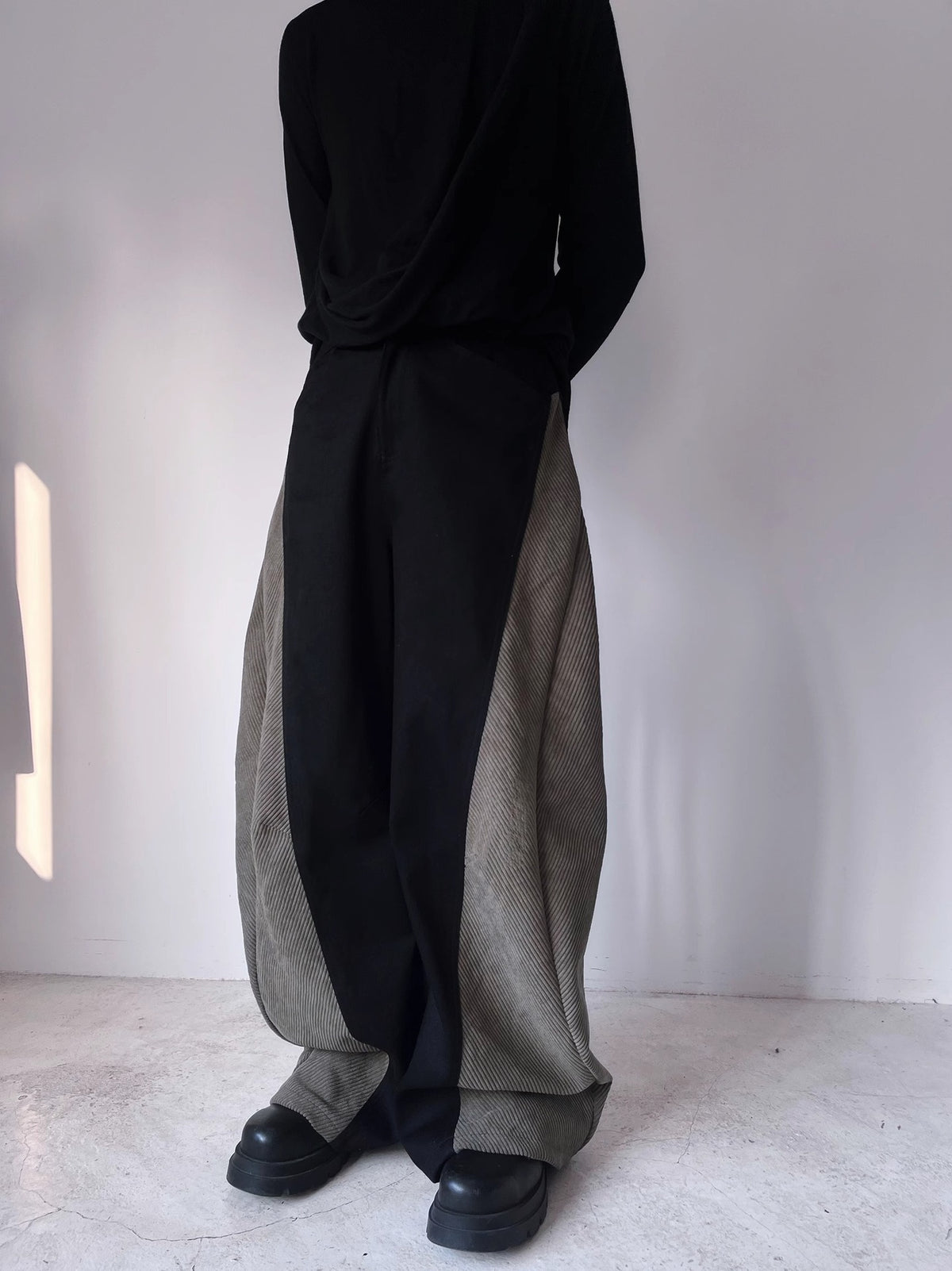 Black wide-leg pants with curved side panels and loose straight silhouette