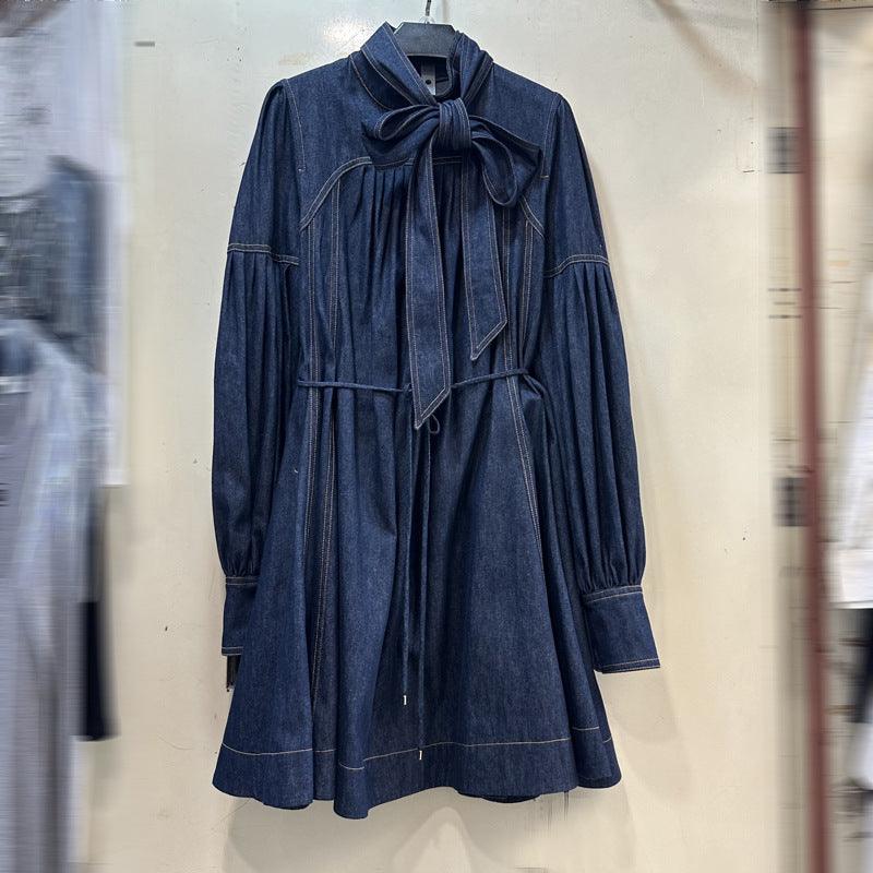 Blue denim dress with stand-up collar bow and flared skirt with pleated seams