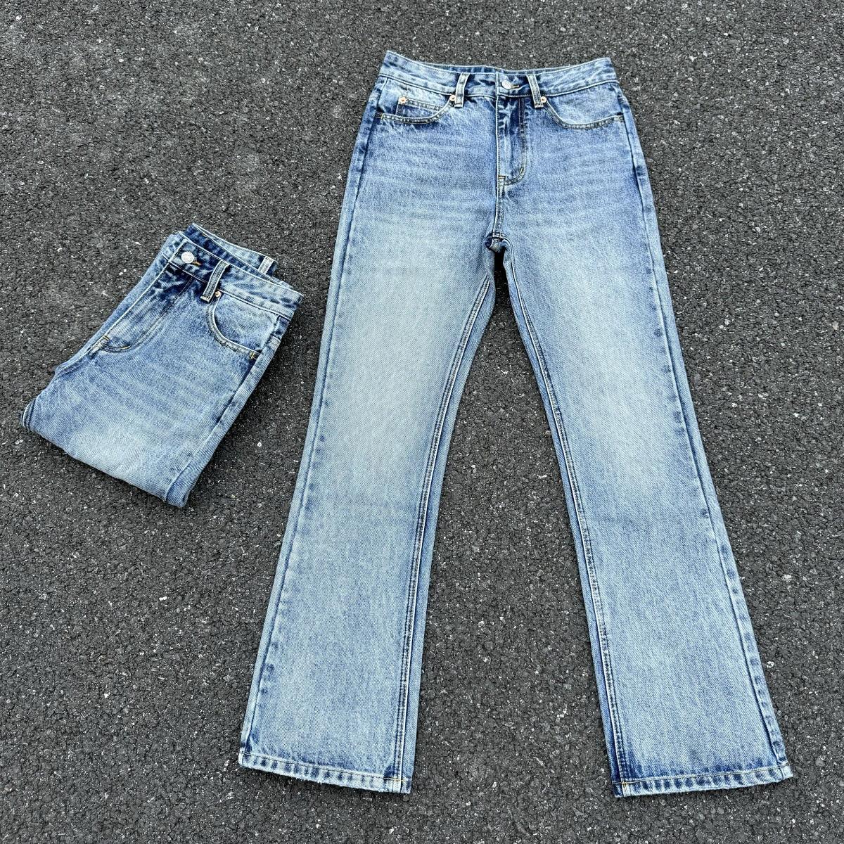 Men's light blue washed wide-leg jeans laid flat with folded spare pair