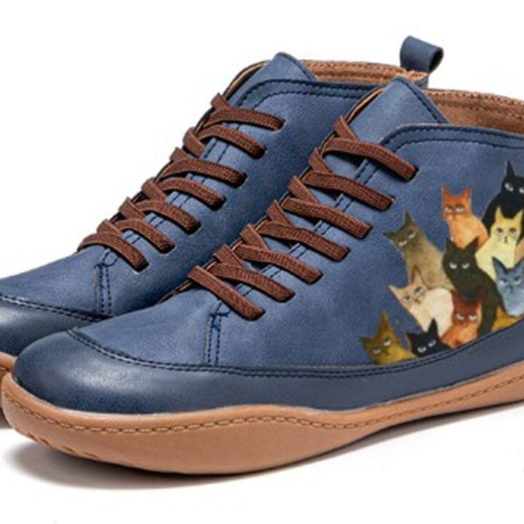 Blue lace-up low-top sneakers with round toe, brown laces, and cat print side panels