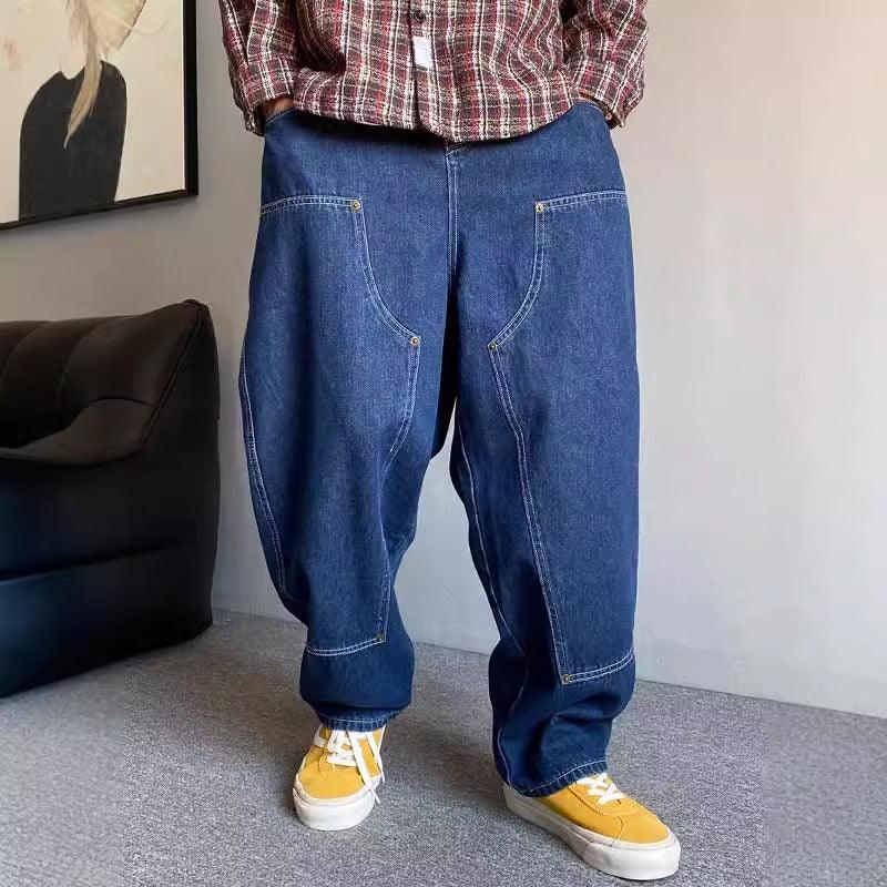 Blue denim loose-fit workwear jeans with patch pockets and visible contrast stitching