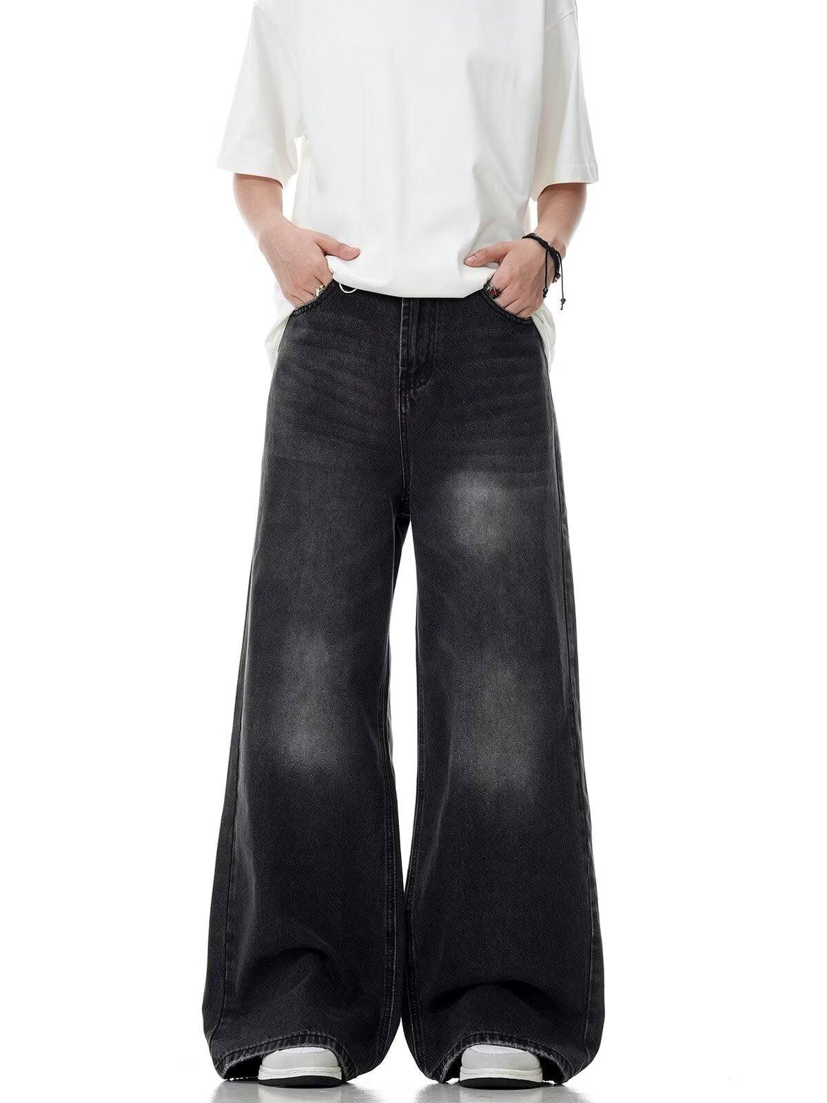 Washed black straight-leg jeans with relaxed wide leg and worn distressed texture