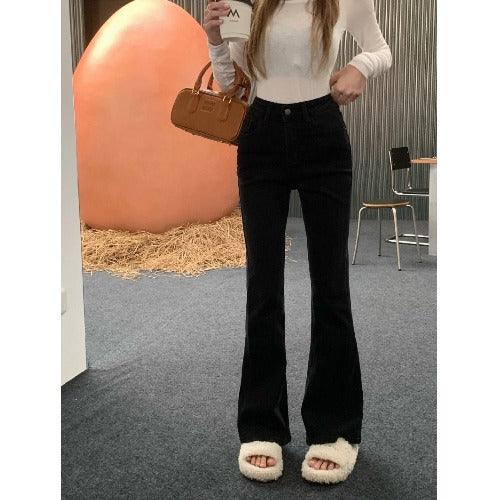 Black low-waist flared skinny jeans with visible waistband button and belt loops