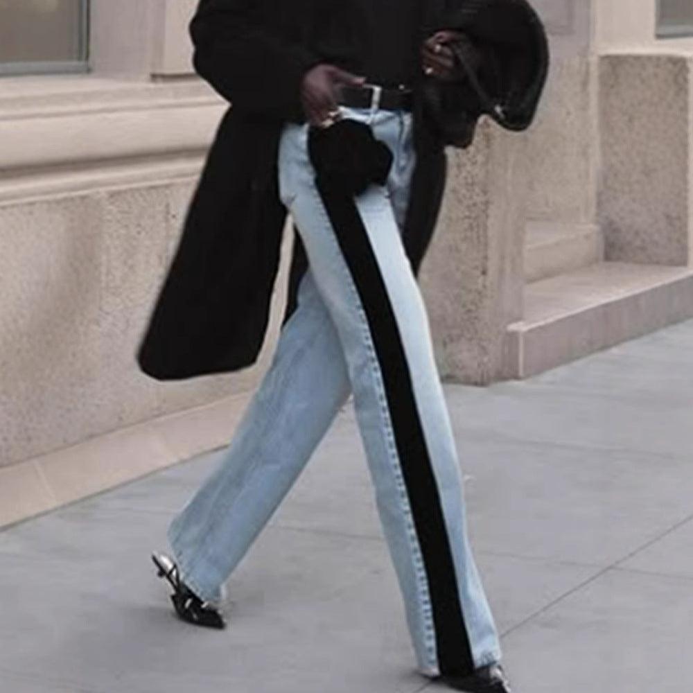 Light-wash denim jeans with wide legs and black side stripe, front button closure