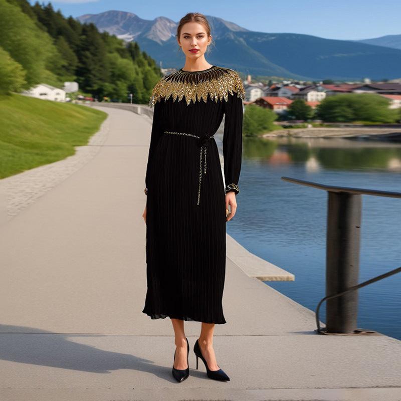 Black pleated maxi dress with gold beaded yoke, long sleeves, fringe and waist tie