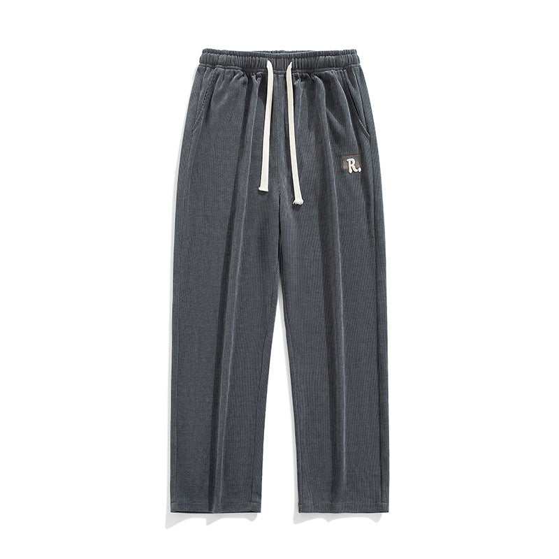 Men's draped casual pants, dark gray with elastic waistband and drawstring ties, logo patch