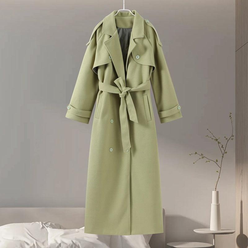 Light green long trench coat with lapel collar, button closure, tied waist belt and pockets.