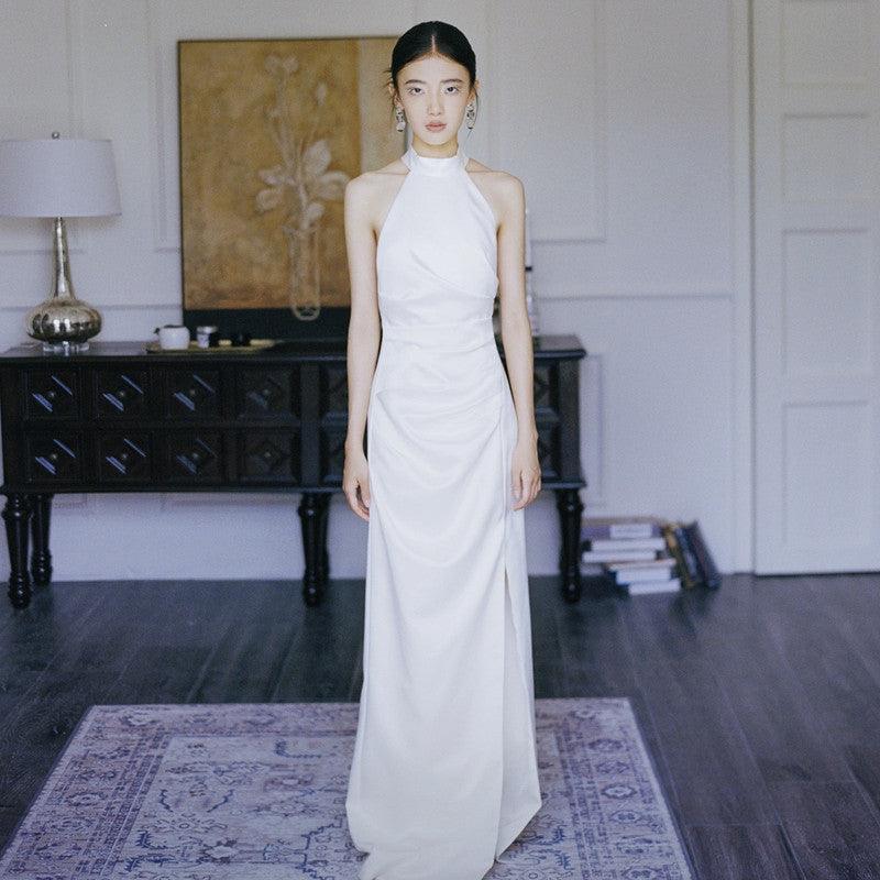 White halter fishtail dress with draped sleeveless bodice and floor-length mermaid hem