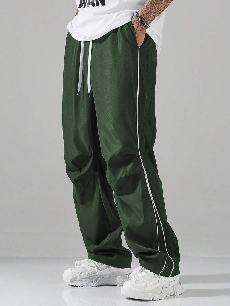 Mens striped track pants, dark green, relaxed fit with side drawstring and vertical piping.