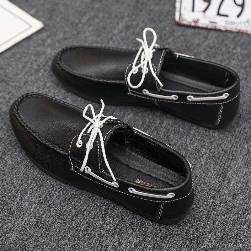 Black boat-style shoes with white laces and moc-toe stitching, low-profile sole