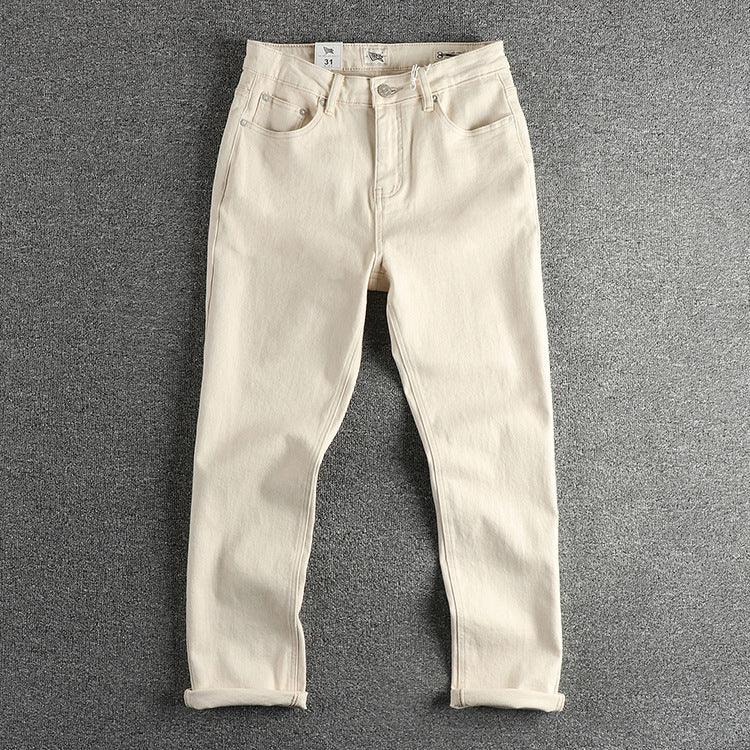 Off-white washed denim jeans, front view with five-pocket design and cuffed hem