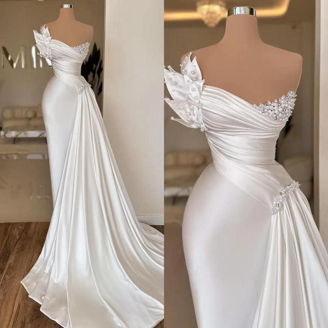 White satin one-shoulder wedding dress with beaded bodice and draped A-line skirt