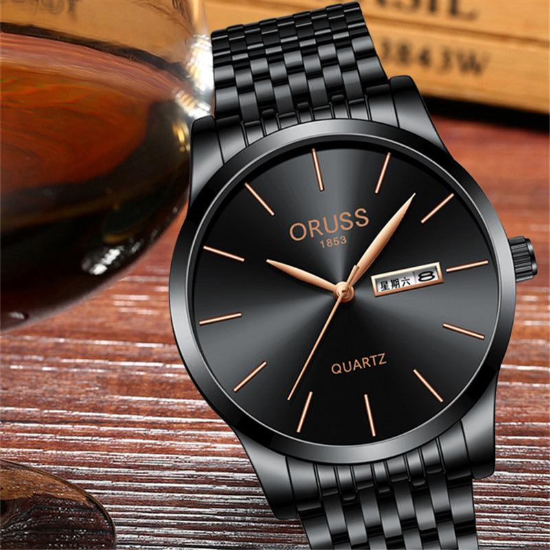 Black metal-link wristwatch with dark dial, gold hands, hour markers, and date display