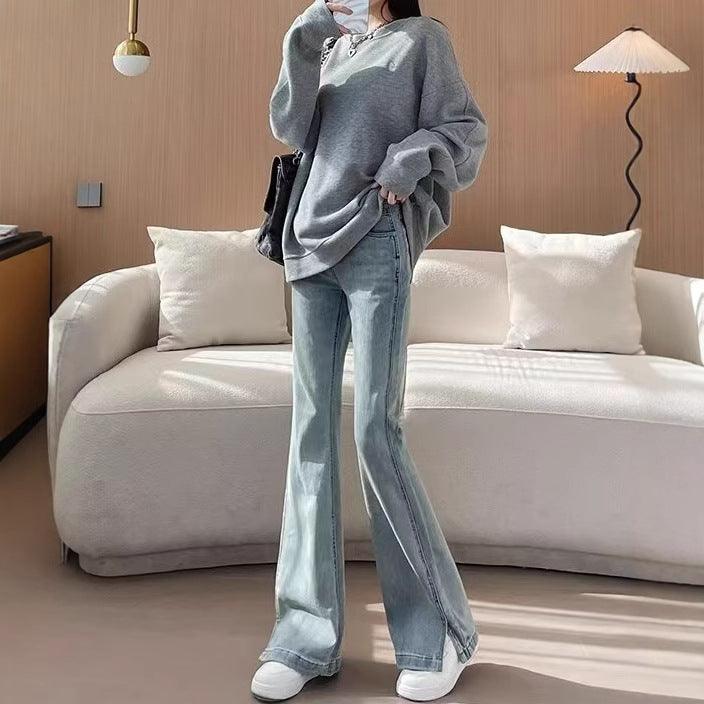 Light blue high-waist slim flared jeans with split hem, button closure, and belt loops