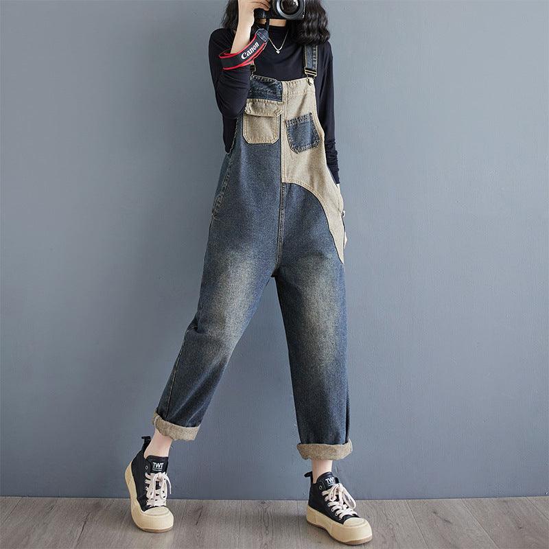 Loose denim suspender pants in dark blue with beige patch pockets and adjustable shoulder straps