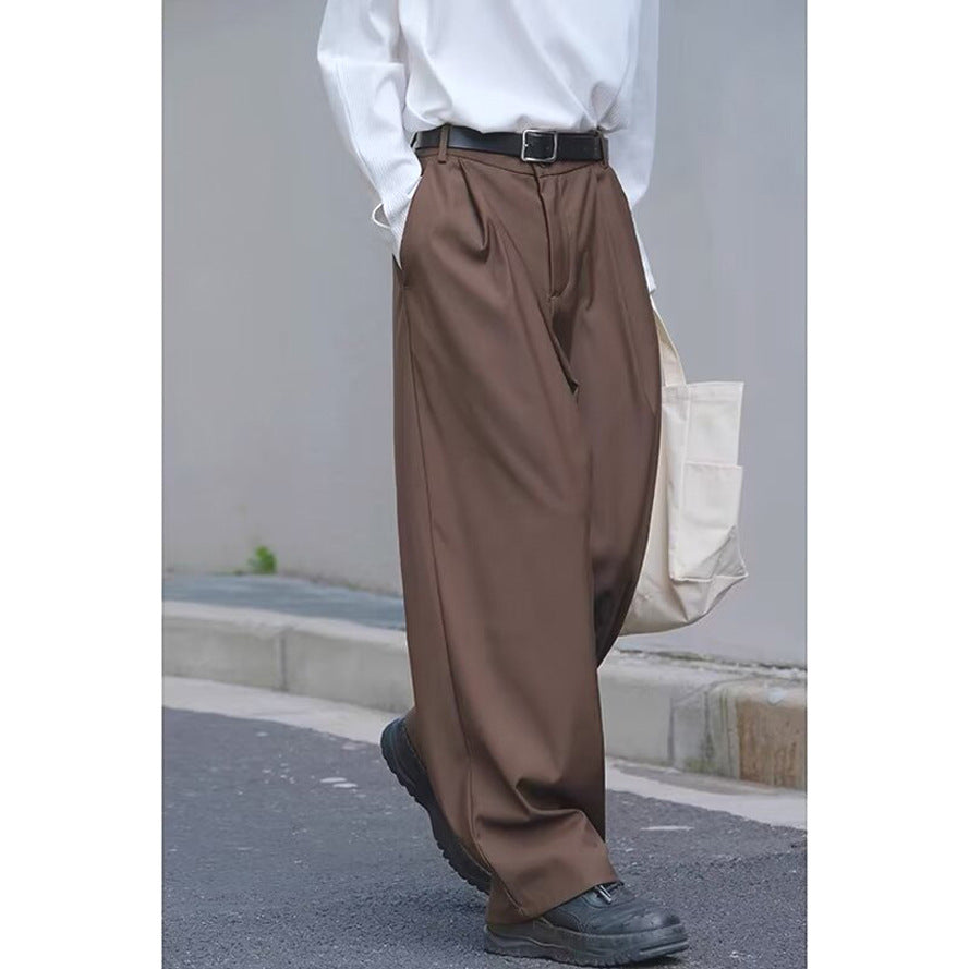 Brown loose straight-leg pants with belt, pleats, and relaxed ankle-length hem.