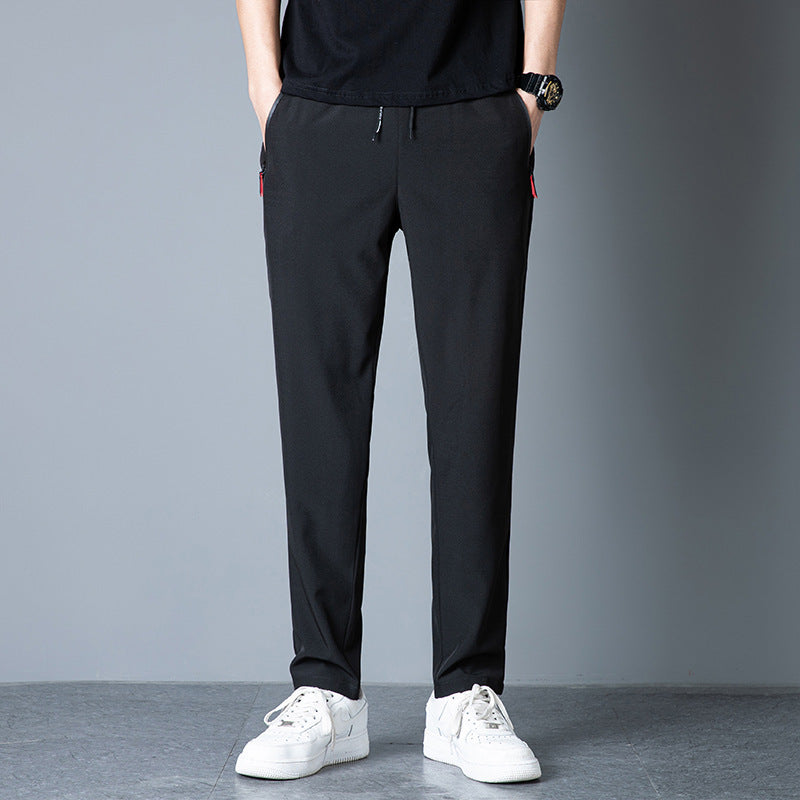 Black slim sports pants with elastic drawstring waist and tapered full-length fit