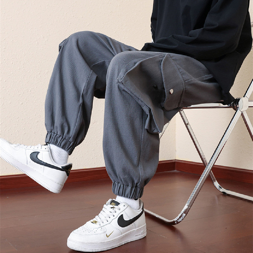 Dark blue loose jogger pants with elastic cuffs and cargo flap pockets